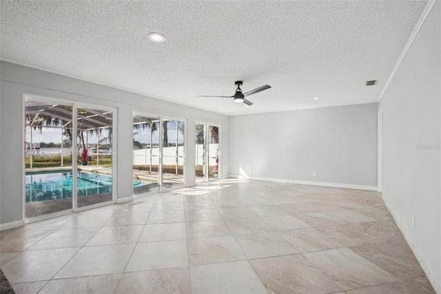 empty room with light tile patterned floors, visible vents, ceiling fan, a textured ceiling, and baseboards