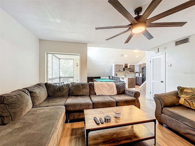 living room with light hardwood / wood-style flooring and ceiling fan