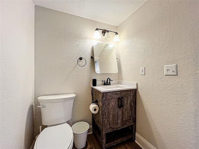 bathroom with vanity, hardwood / wood-style floors, a textured ceiling, and toilet