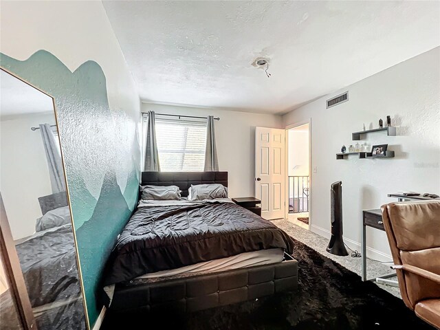 bedroom with a textured ceiling and carpet flooring