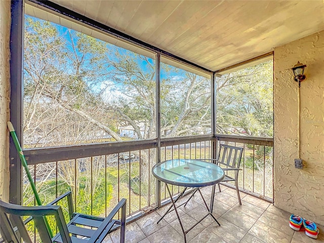 unfurnished sunroom featuring plenty of natural light and wooden ceiling