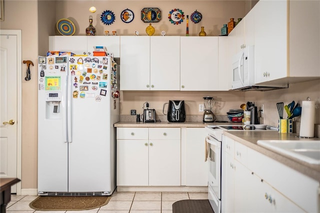 kitchen with light tile patterned floors, white cabinets, and white appliances