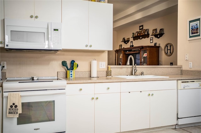 kitchen featuring sink, white appliances, and white cabinets