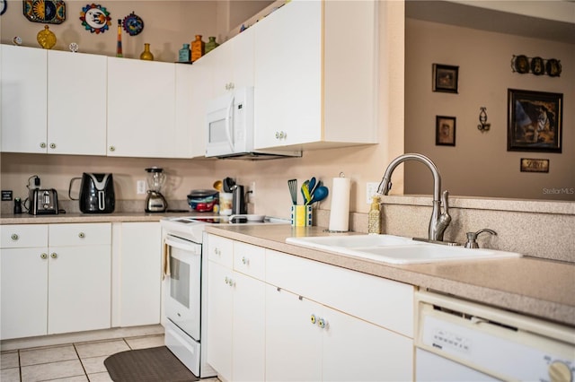 kitchen featuring sink, white appliances, white cabinets, and light tile patterned flooring