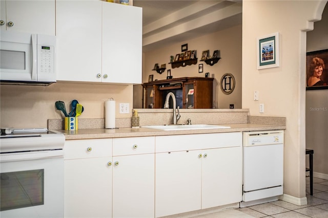 kitchen featuring white cabinetry, sink, light tile patterned floors, and white appliances