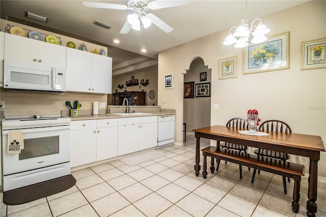 kitchen featuring light tile patterned flooring, white cabinetry, sink, hanging light fixtures, and white appliances