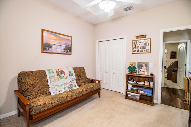 sitting room with ceiling fan and light carpet