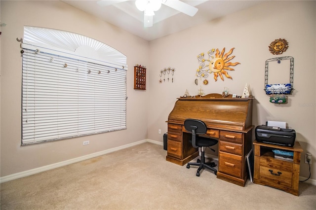 carpeted home office featuring ceiling fan