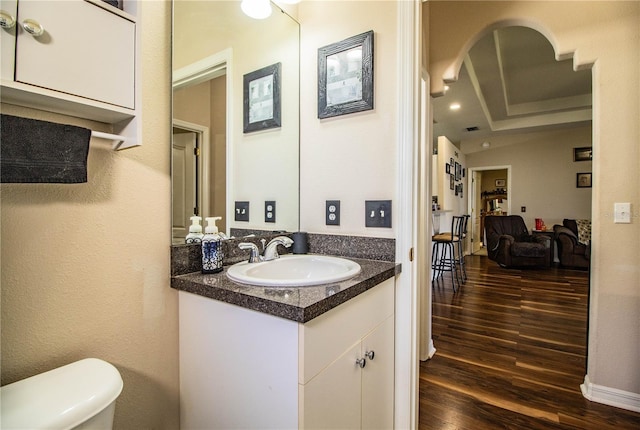 bathroom featuring vanity, hardwood / wood-style floors, and toilet