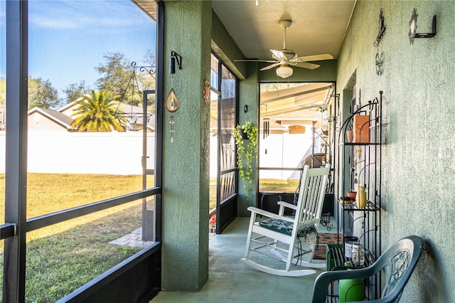 sunroom / solarium featuring a healthy amount of sunlight and ceiling fan