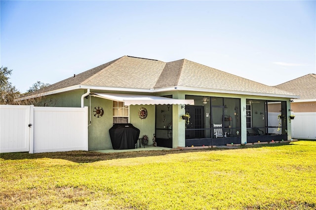 view of front of home featuring a sunroom and a front yard