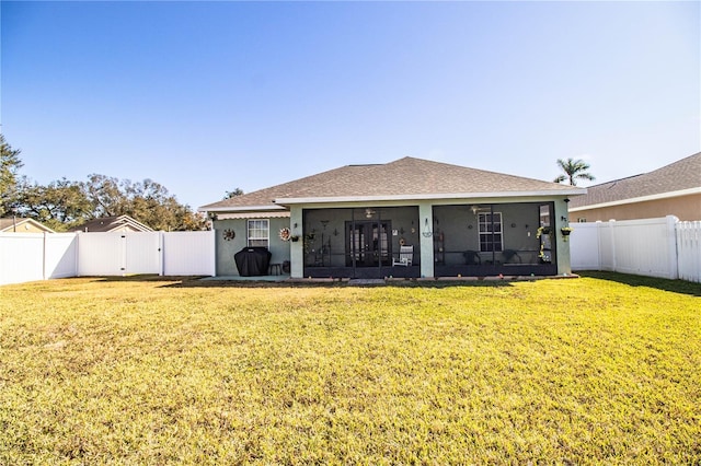 back of property with a yard and a sunroom