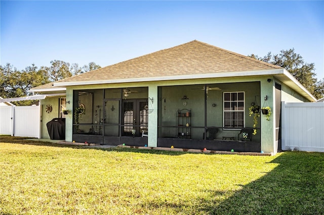 view of front of property featuring a front yard, a sunroom, and ceiling fan