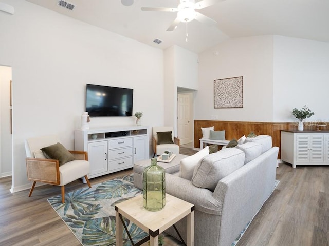 living room with ceiling fan, lofted ceiling, and light hardwood / wood-style floors