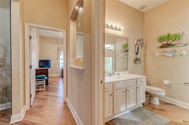 bathroom featuring vanity, hardwood / wood-style floors, and toilet