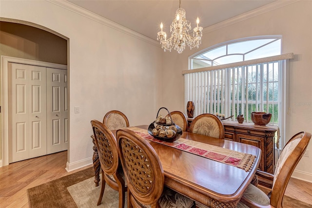 dining room featuring ornamental molding, a chandelier, and light hardwood / wood-style flooring