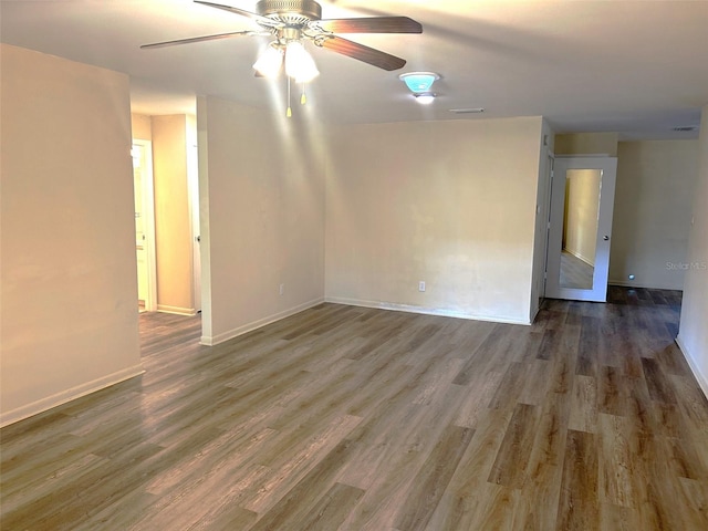 empty room with ceiling fan and dark hardwood / wood-style flooring