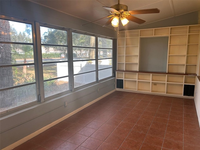 unfurnished sunroom with ceiling fan, plenty of natural light, and vaulted ceiling