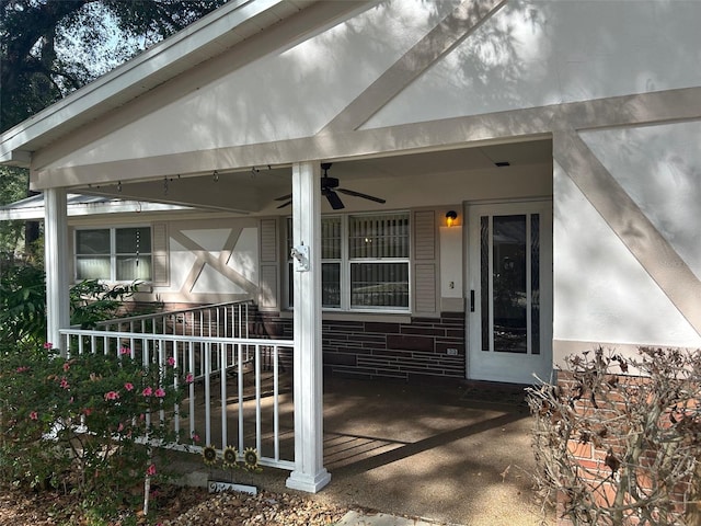 entrance to property with ceiling fan and a porch