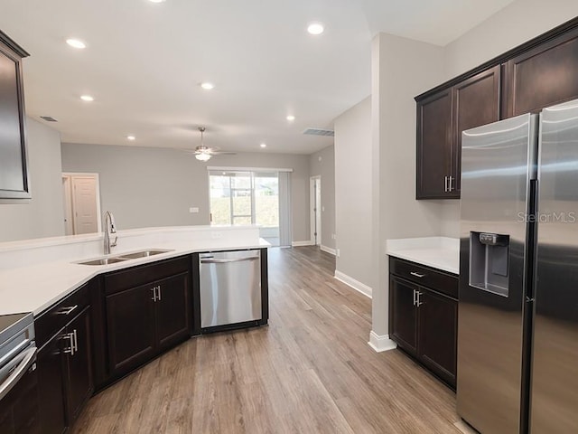 kitchen with sink, ceiling fan, dark brown cabinetry, stainless steel appliances, and light hardwood / wood-style floors