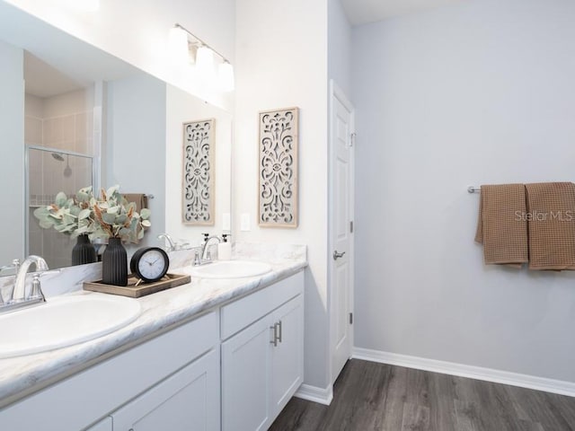 bathroom with hardwood / wood-style flooring, vanity, and an enclosed shower