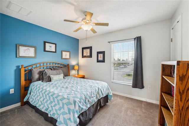 bedroom with ceiling fan, carpet floors, and a textured ceiling