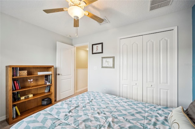 bedroom with a textured ceiling, a closet, and ceiling fan