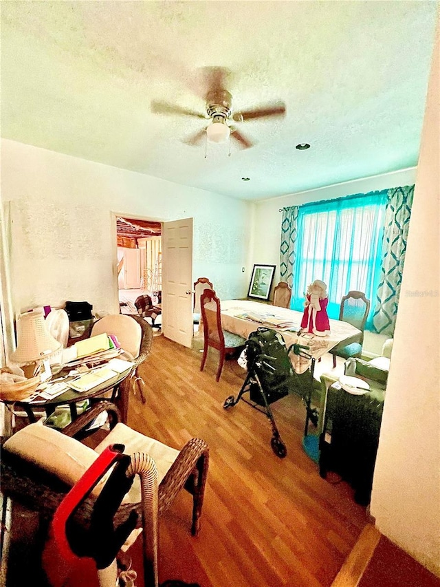 bedroom with wood-type flooring, ceiling fan, and a textured ceiling