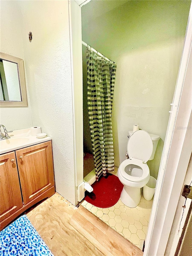 bathroom featuring walk in shower, vanity, and toilet