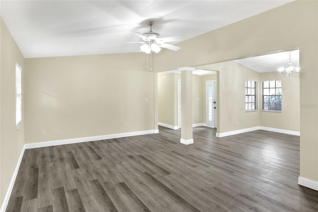 spare room featuring dark wood-type flooring, lofted ceiling, and ceiling fan with notable chandelier