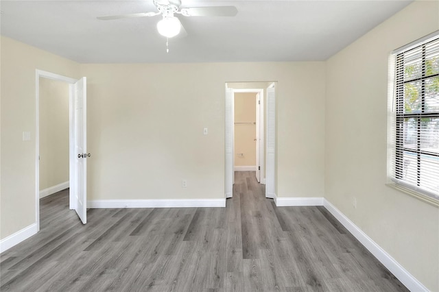 empty room with ceiling fan and light hardwood / wood-style flooring