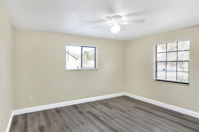 unfurnished room with ceiling fan, dark hardwood / wood-style flooring, and a textured ceiling