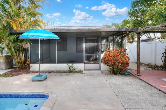 rear view of house featuring a fenced in pool, a patio area, and a sunroom