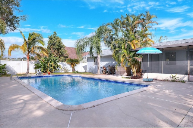 view of swimming pool with a patio area and a sunroom