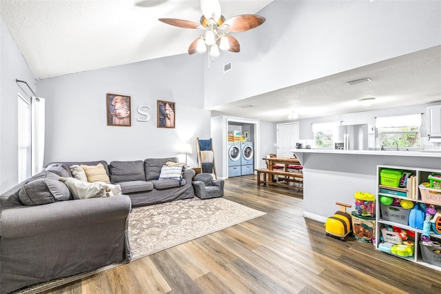 living room featuring ceiling fan, hardwood / wood-style flooring, washer and dryer, and a textured ceiling