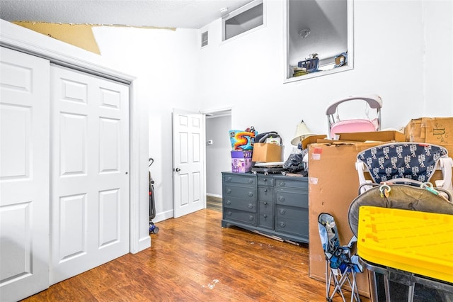 bedroom featuring dark hardwood / wood-style flooring, a closet, and a textured ceiling