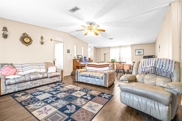 living room with ceiling fan, dark wood-type flooring, and a textured ceiling