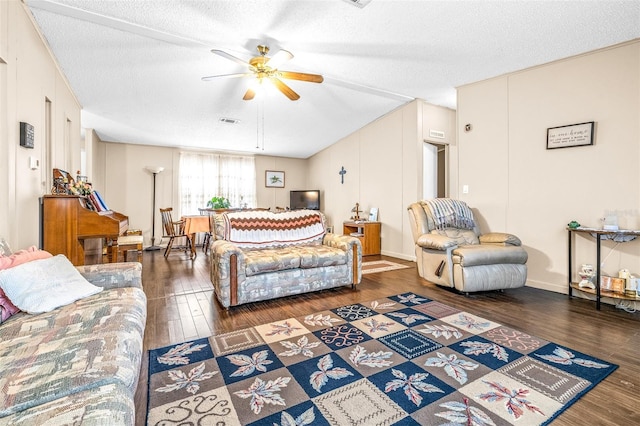 living room featuring ceiling fan, dark hardwood / wood-style flooring, and a textured ceiling