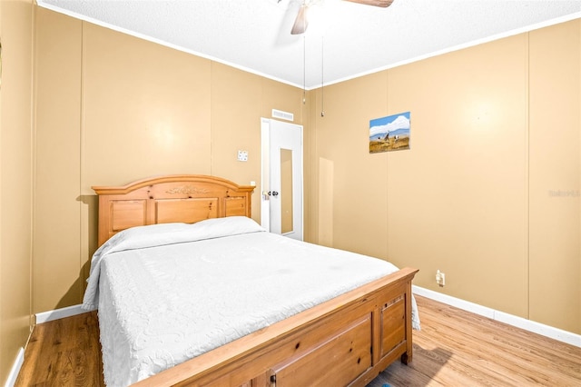 bedroom with crown molding, light hardwood / wood-style floors, and ceiling fan