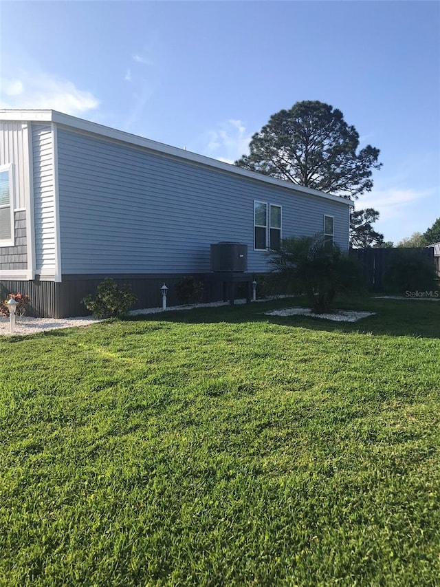 exterior space featuring central AC unit and a yard