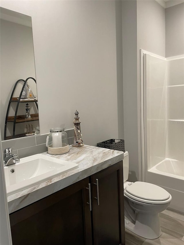 full bathroom featuring vanity, bathtub / shower combination, and toilet