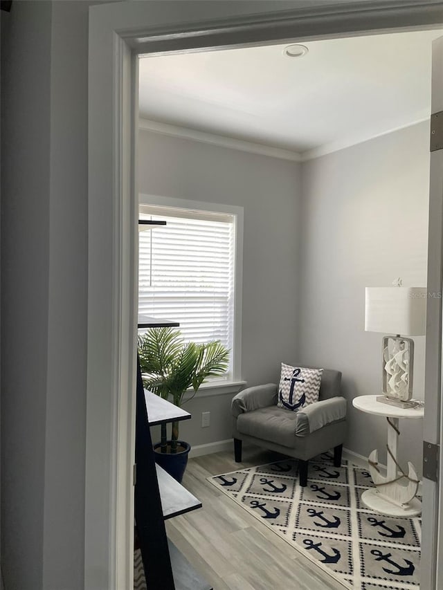 sitting room featuring crown molding, wood finished floors, and baseboards