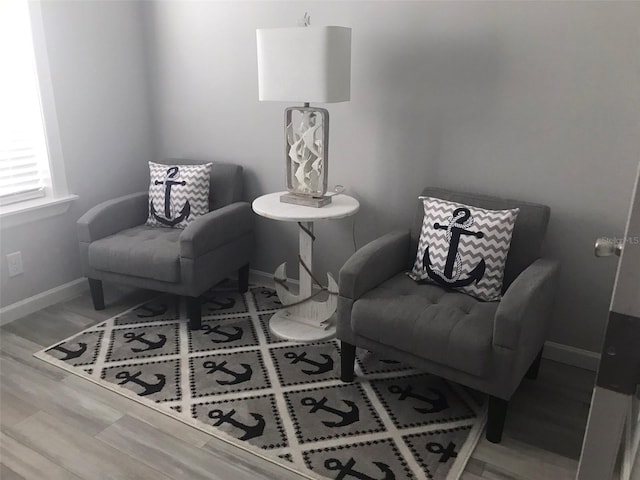 living area with baseboards and wood finished floors