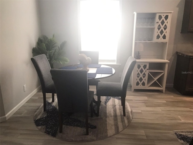 dining room with baseboards and light wood finished floors