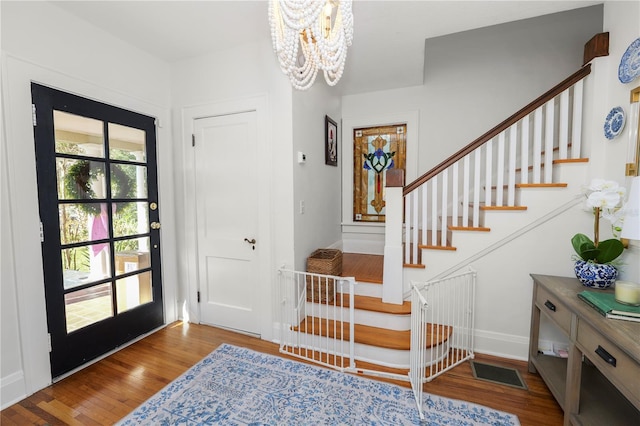 foyer with hardwood / wood-style flooring and an inviting chandelier