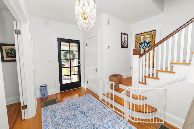 entryway with hardwood / wood-style floors and an inviting chandelier