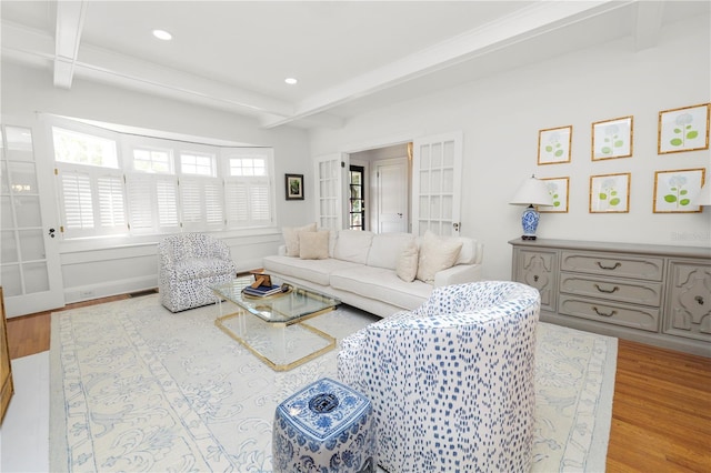 living room with beamed ceiling, coffered ceiling, and light wood-type flooring