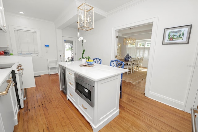 kitchen featuring white cabinetry, stainless steel microwave, decorative light fixtures, and a notable chandelier