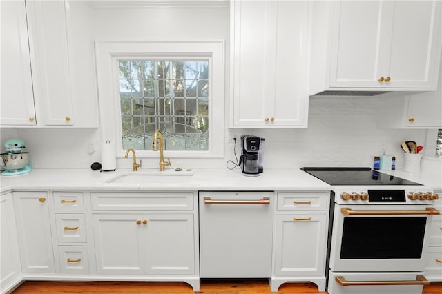 kitchen featuring white electric range, sink, decorative backsplash, and white cabinets