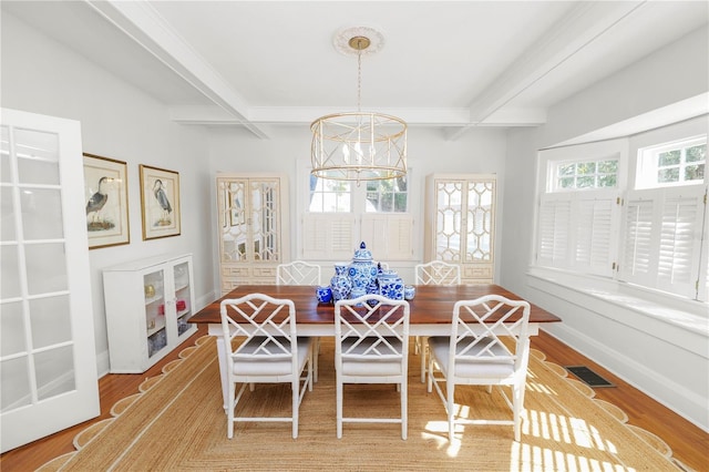 dining space featuring beam ceiling, a notable chandelier, light hardwood / wood-style floors, and breakfast area